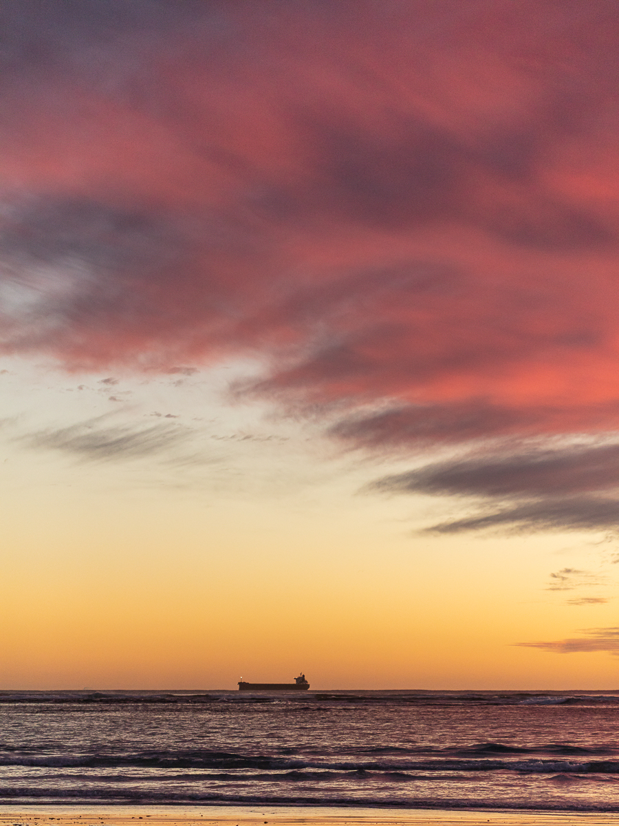 Sunset photo of Point Moore with a pink sky and ship on the horizon